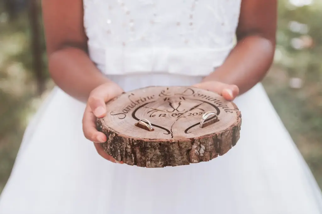 Détail de porte-alliances artisanal en bois gravé, photographie de détails de mariage personnalisés et authentiques au Studio Timeless à Limoges.