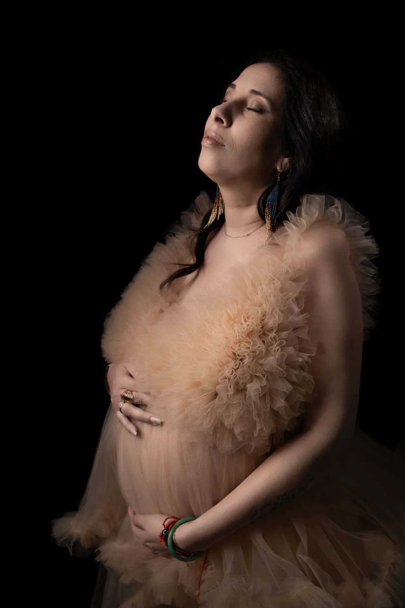 Femme enceinte en robe tulle doré sur fond sombre séance maternité Limoges