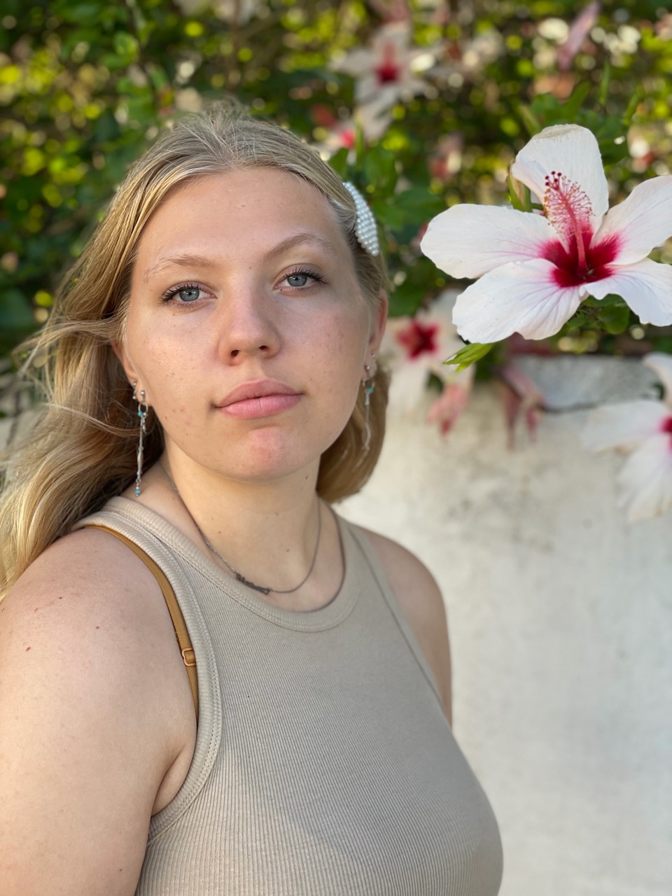 Portrait en extérieur d’une femme près d’une fleur d’hibiscus