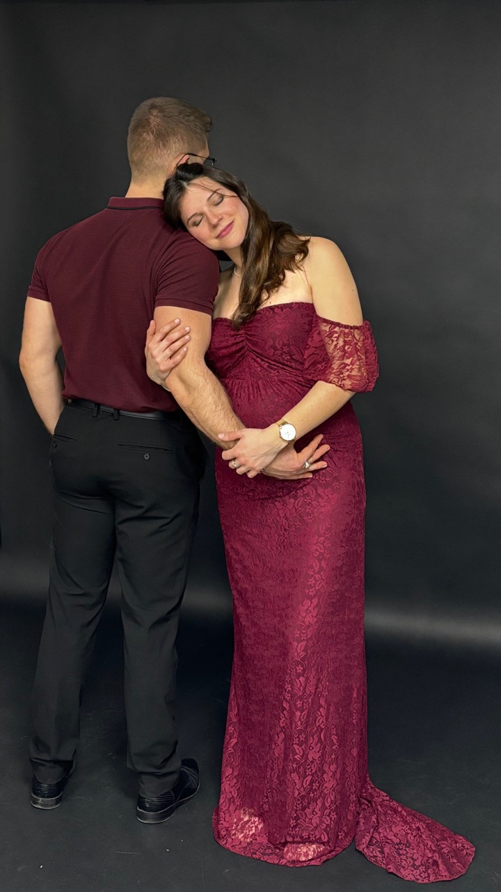 Un couple enlacé devant un fond sombre au studio.